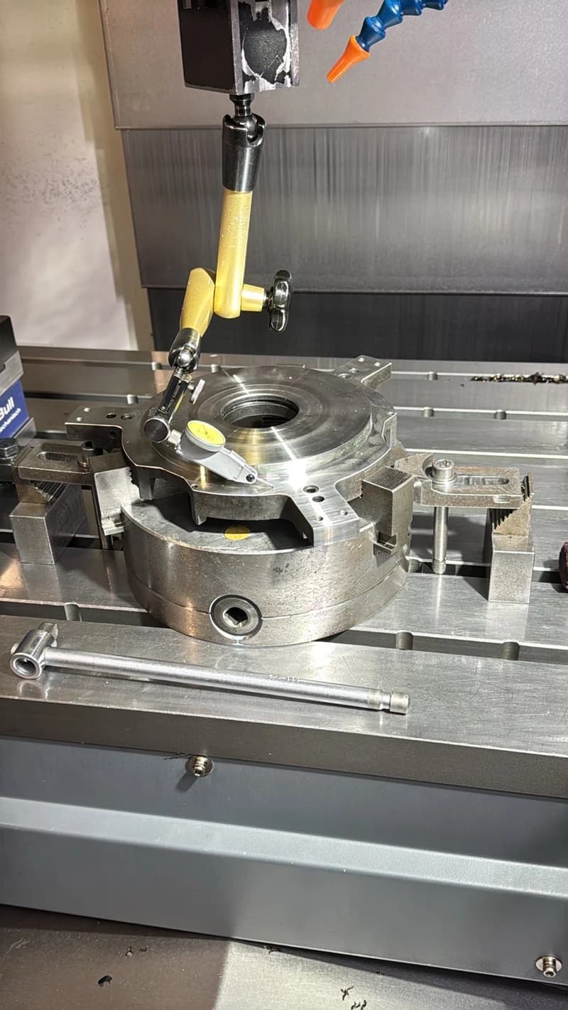 Eine Messuhr wird verwendet, um ein metallisches Werkstück auf einer Werkzeugmaschine zu messen. Das Werkstück ist in einer Vorrichtung befestigt und die Messuhr ist an einem magnetischen Stativ befestigt.